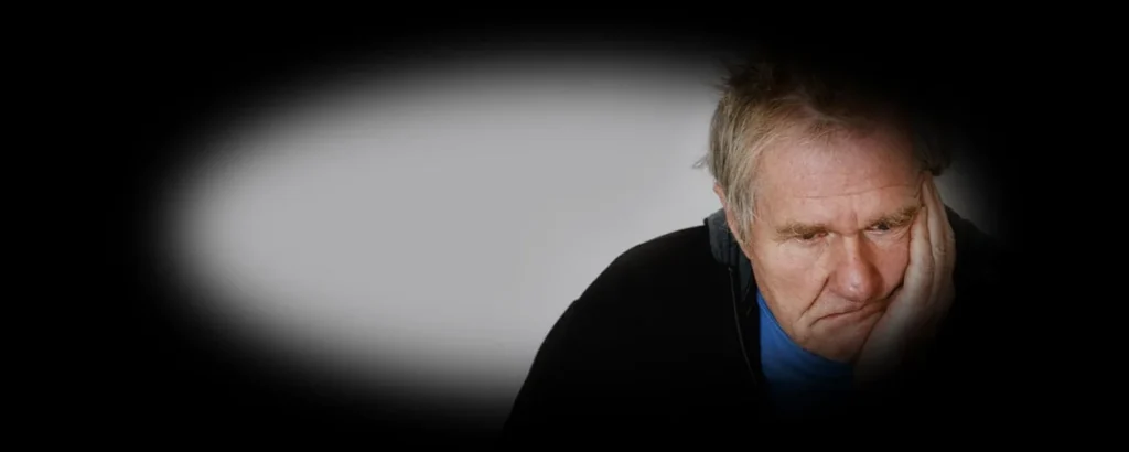 Older male with his head resting on his hand.